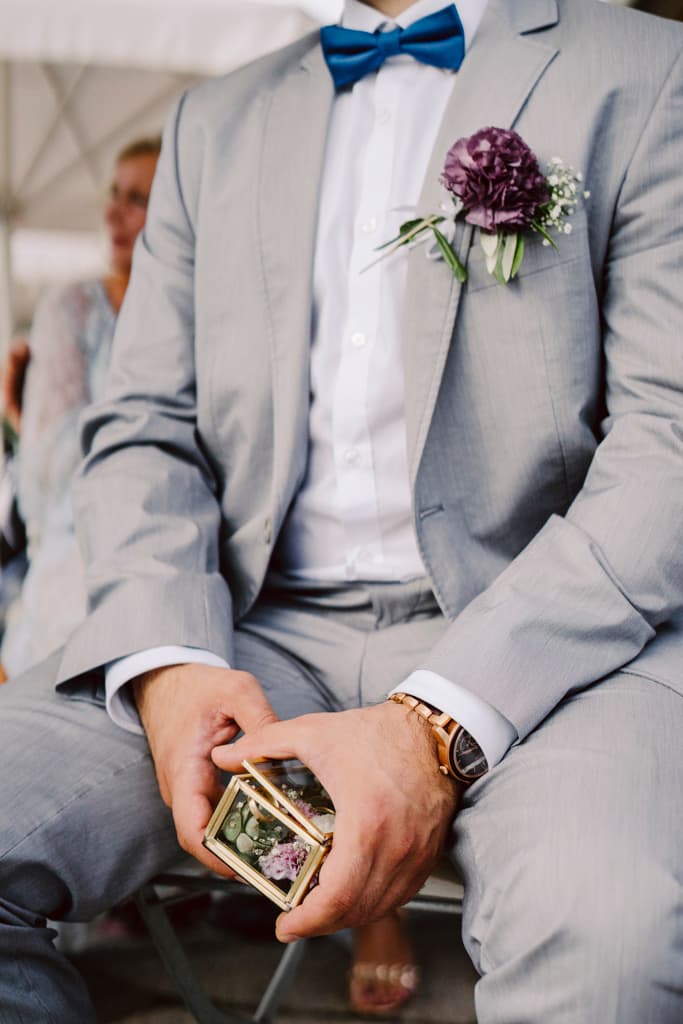 close up of best man holding wedding rings