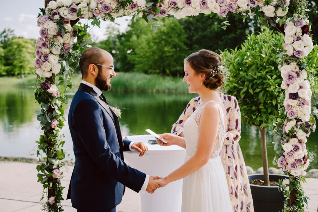 bride reading bridal vow to the groom during wedding ceremony at Cafe Seestern in Britzer Garten in Berlin