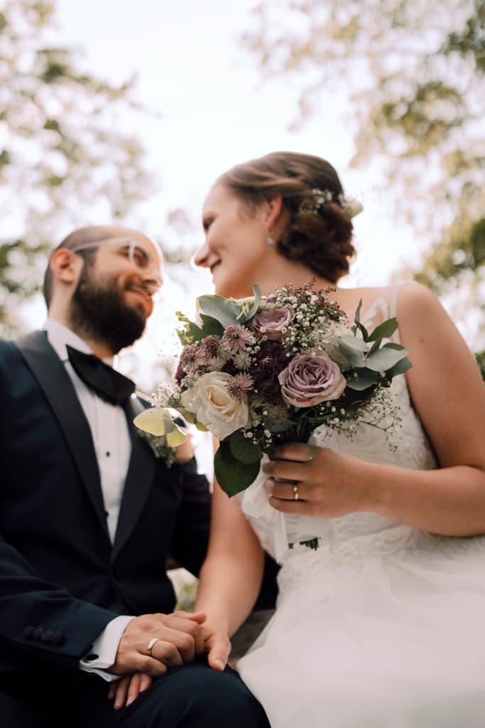 bride and groom holding hands with bridal bouquet