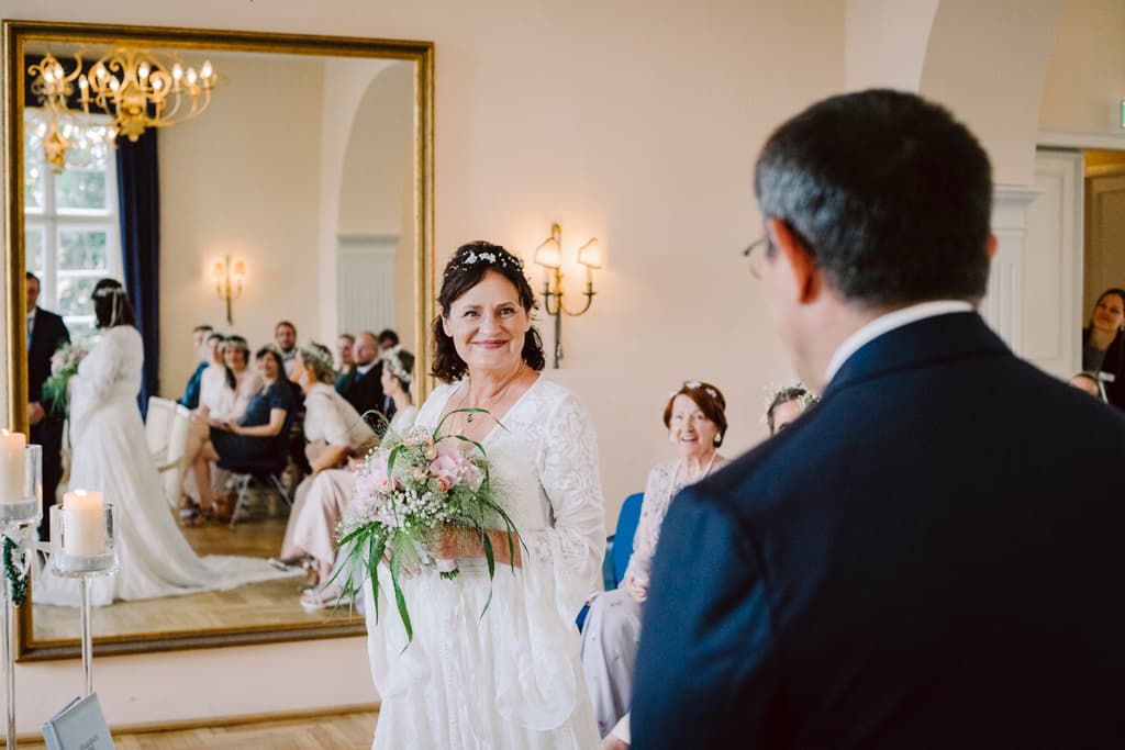 bride and groom in front of the mirror of the ballroom mansion Lübbenau by Berlin