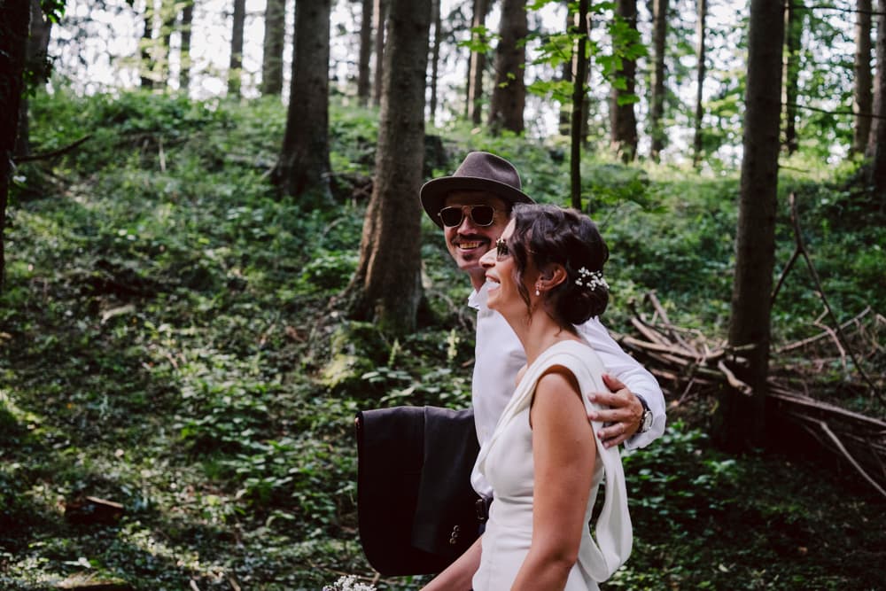 Wedding couple wandering through the forest to the Doagl Alm in Samerberg in Bayern